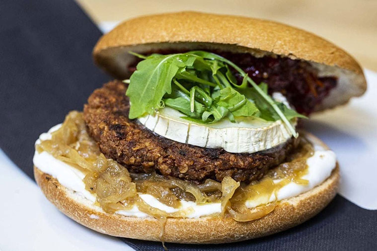 hamburguesa con queso de cabra, cebolla caramelizada y chutney de piquillos casero y rúcula
