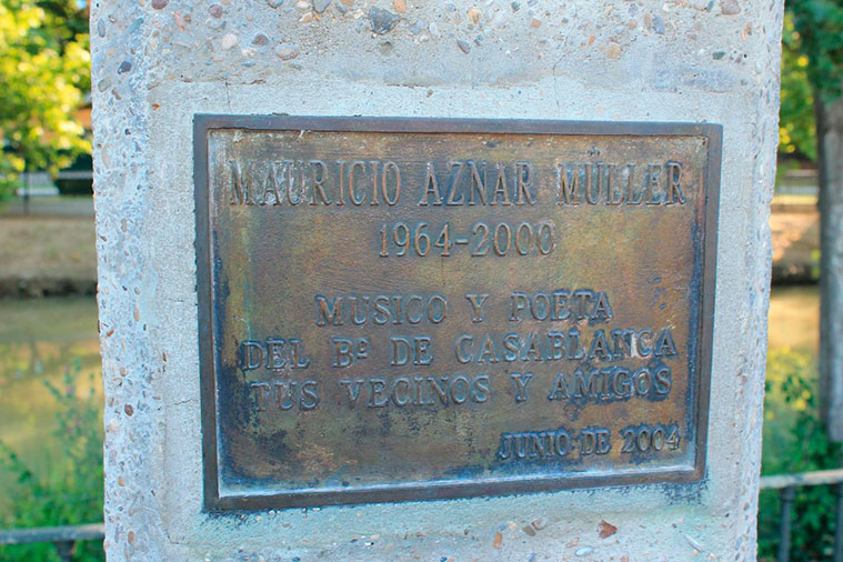 El busto se apoya sobre un pedestal de piedra que lleva inserto una placa con lo siguiente: "Mauricio Aznar Müller (1964-2000) Músico y poeta del Barrio de Casablanca. Tus vecinos y amigos. Junio de 2004".
