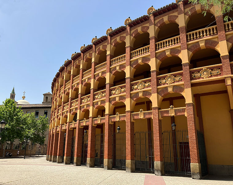 Exterior de la Plaza de Toros de La Misericordia con el Edificio Pignatelli al fondo