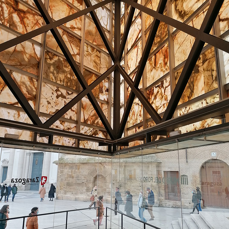 El Museo del Foro Romano de Caesaraugusta se encuentra en un edificio subterráneo, al que se accede a través de un prisma de ónice iraní situado en la Plaza la Seo, junto a la Catedral de la Seo