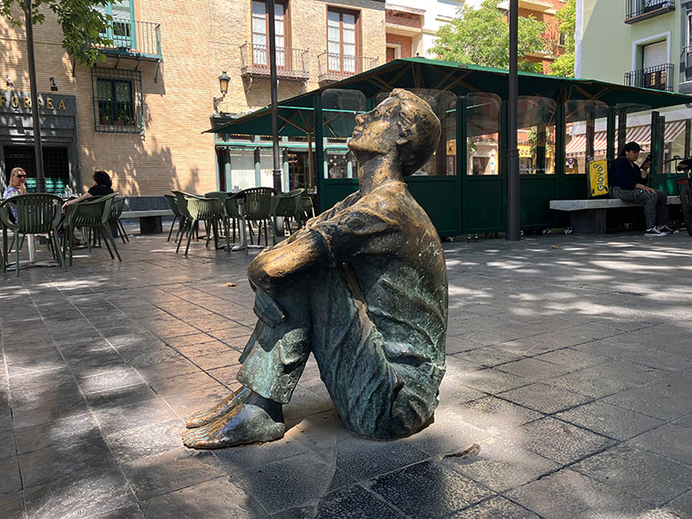 Plaza de San Felipe, donde se encontraba la Torre Nueva. La escultura de un muchacho sentado mira hacia el lugar en que se alzó la torre, señalado por hitos de piedra.