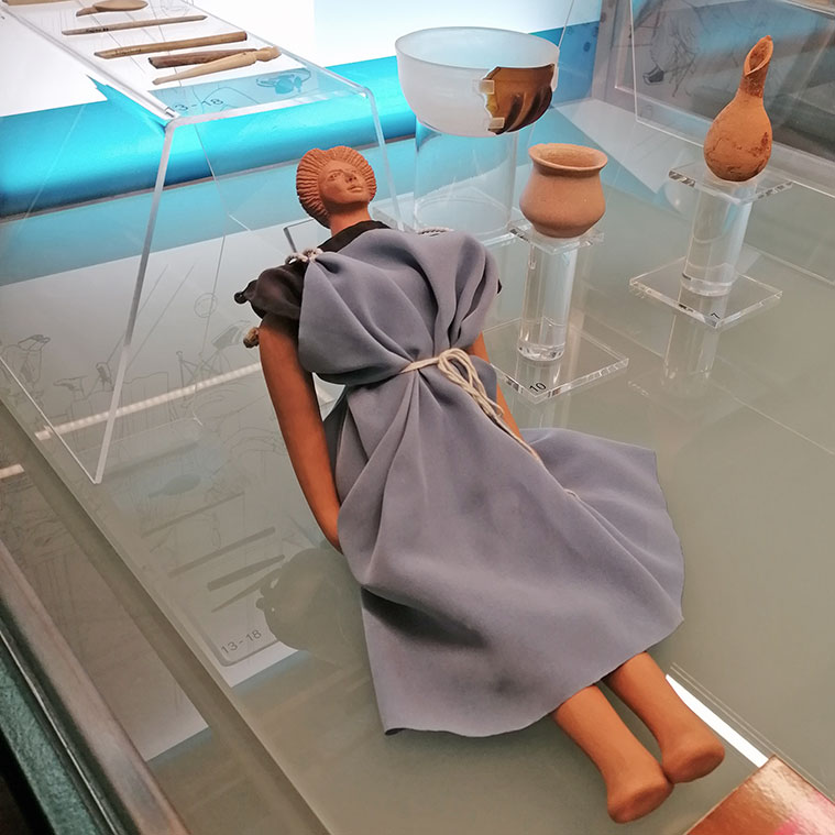 En el Museo Foro de Caesaraugusta se puede contemplar una reproducción de una muñeca de época romana del siglo I d.C. Esta pieza, de gran realismo, nos permite acercarnos a la vida cotidiana de las niñas romanas de la época.