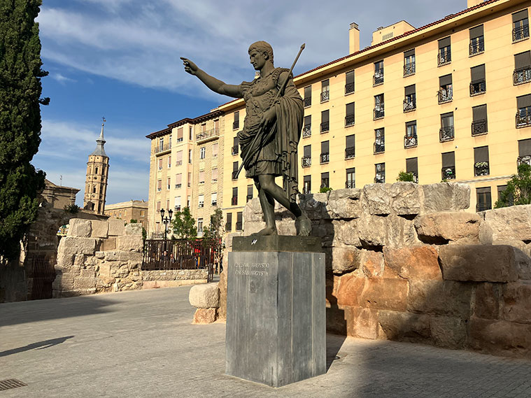 La estatua como tributo al emperador César Augusto, quien estableció la ciudad de Zaragoza, se alza majestuosa en las inmediaciones de las murallas romanas.
