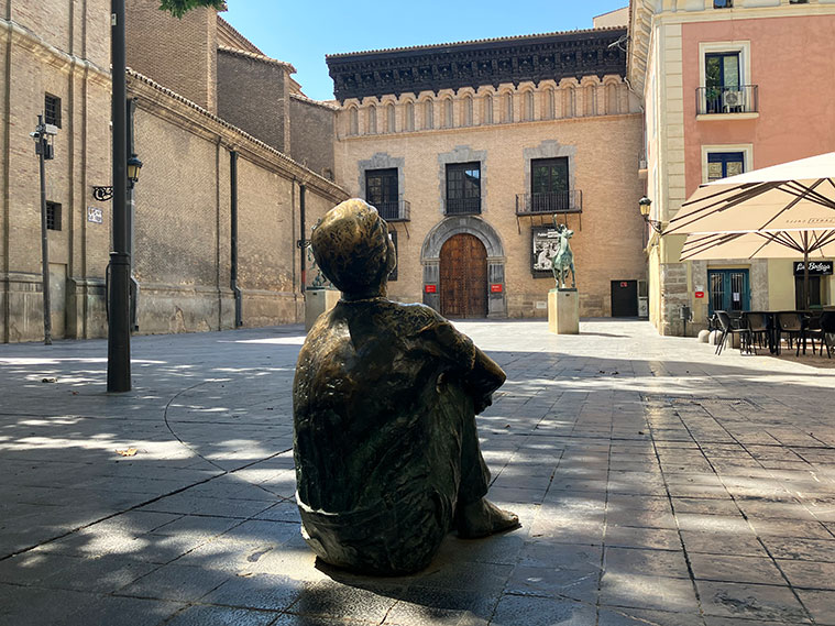 Escultura 'Niño sentado mirando a la Torre Nueva' de Santiago Gimeno Llop