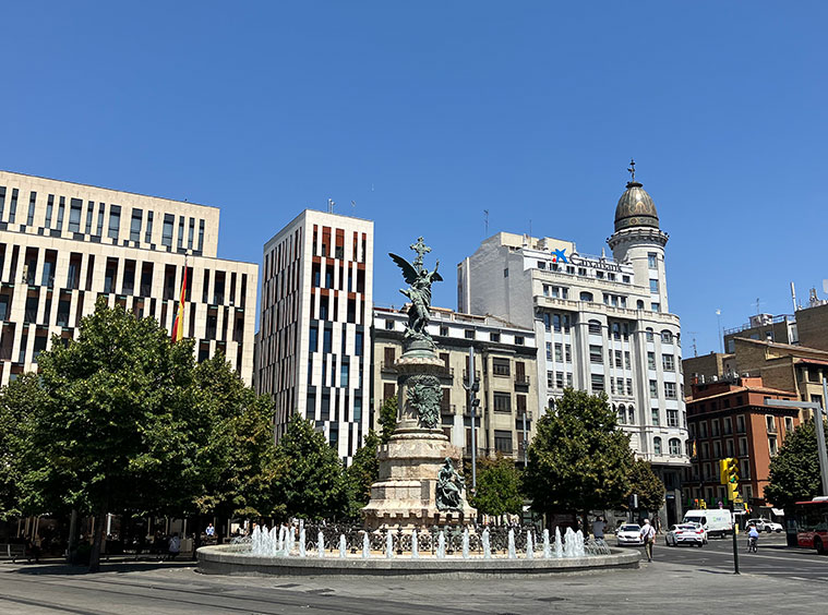 La Plaza de España de Zaragoza, con el edificio de Puerta Cinegia a la izquierda, el monumento a los Mártires en el centro y la antigua sede del Banco Zaragozano a la derecha