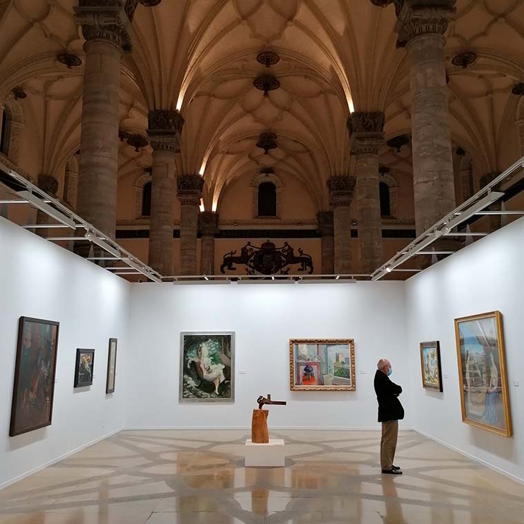 Un visitante contempla una obra en una exposición en La Lonja