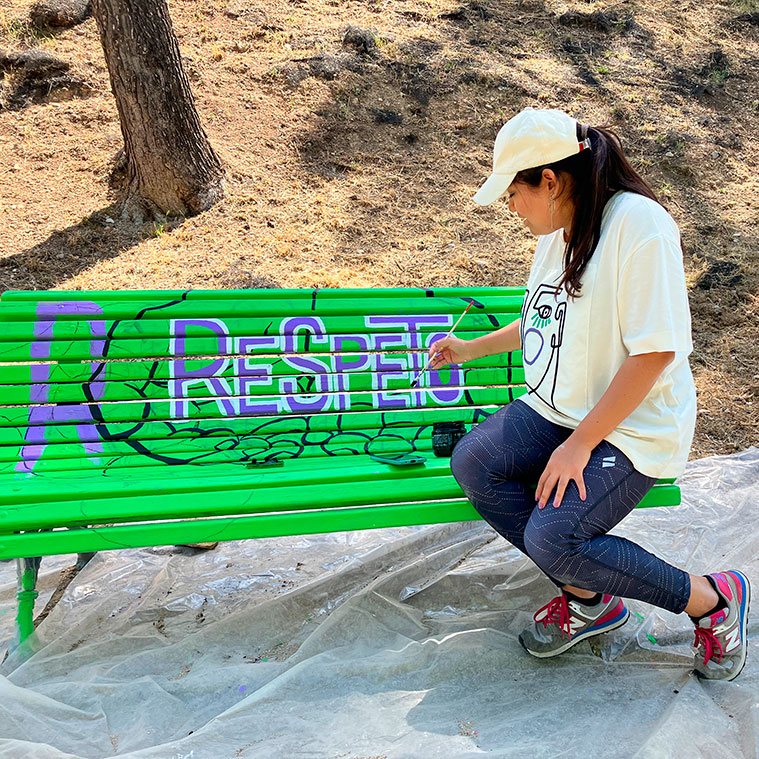 La artista Sharon Chicaiza interviniendo artísticamente un banco del Parque Grande