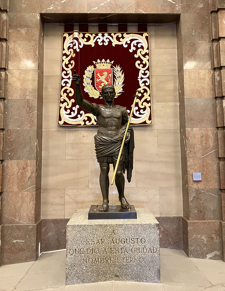 El vestíbulo de la Casa Consistorial acoge una estatua de César Augusto, una réplica a menor tamaño de la que se encuentra en las Murallas Romanas. Fue realizada en 1976 por el escultor aragonés Paco Rallo.