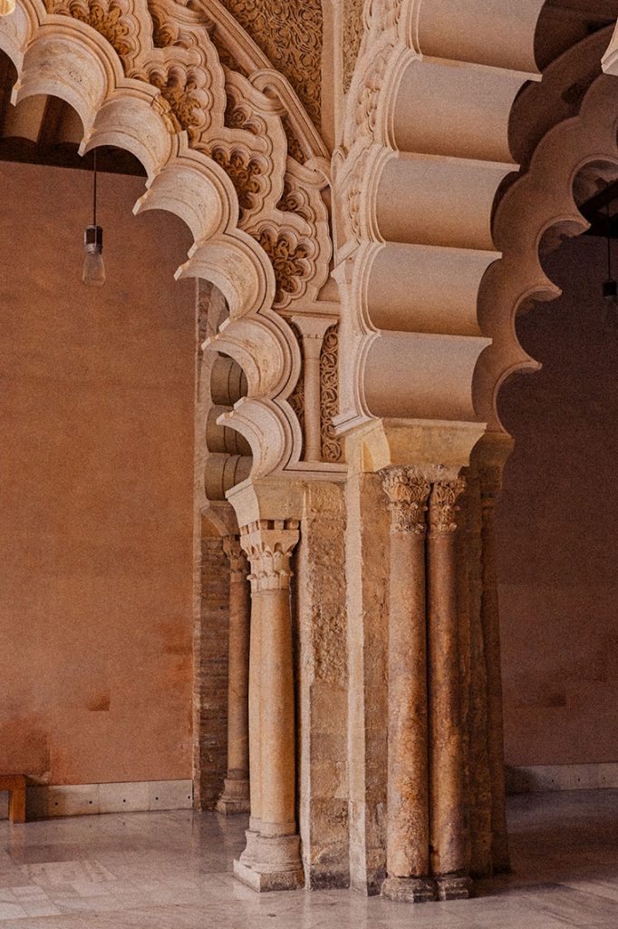 En el acceso al Salón Dorado de la Aljafería se reprodujo el lado norte de la arquería de la mezquita aljama de Córdoba mediante arcos entrelazados que se coronan por un bucle decorativo
