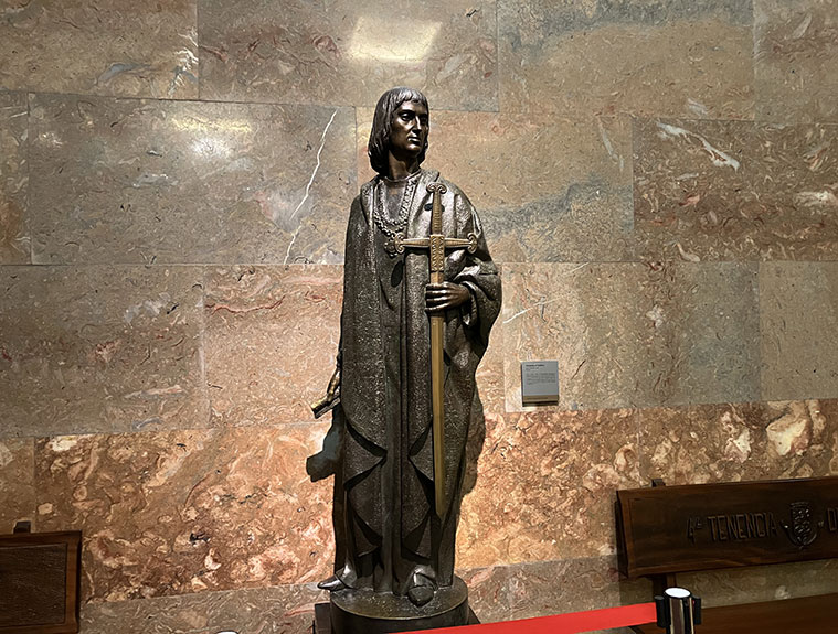 En el descanso de la Escalera Honor se encuentra una escultura de Fernándo el Católico, una réplica a menor tamaño de la que se encuentra en la Plaza San Francisco.