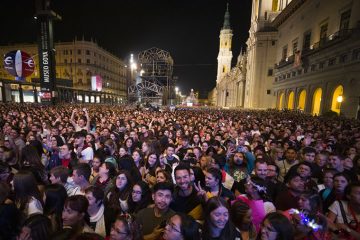 Escenario iluminado en la Plaza del Pilar de Zaragoza con público disfrutando de un concierto gratuito de las Fiestas del Pilar