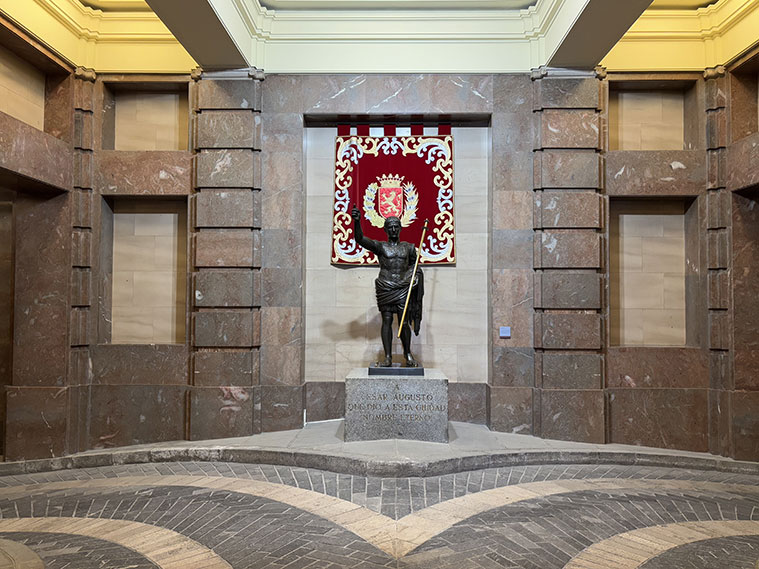 El vestíbulo de la Casa Consistorial acoge una estatua de César Augusto, una réplica a menor tamaño de la que se encuentra en las Murallas Romanas. Fue realizada en 1976 por el escultor aragonés Paco Rallo.
